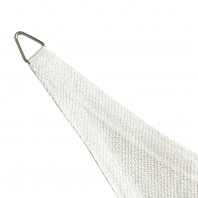 A close-up of the corner of a white sail shade with a metal D-ring attachment.