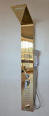 A gold-colored shower panel mounted on a white wall.