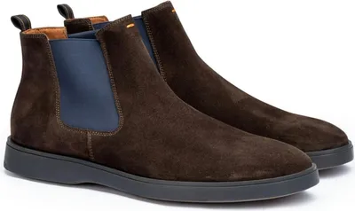 A pair of brown suede Chelsea boots with blue elastic side panels and a dark grey sole, shown against a white background.