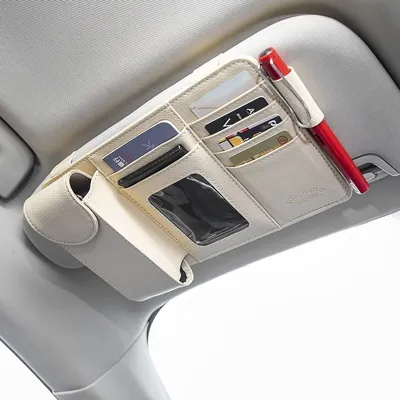 A car sun visor organizer with multiple pockets and a pen holder, attached to a car's sun visor.