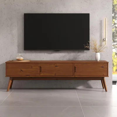 A wooden TV stand with a black TV mounted on a concrete wall.