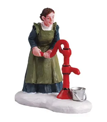 Eine Frau die an einer roten Handwasserpumpe Wasser schöpft. Sie trägt ein traditionelles Kleid.