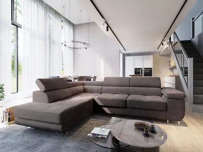 A modern living room with a large sectional sofa, coffee table, and stairs leading to an upper level.