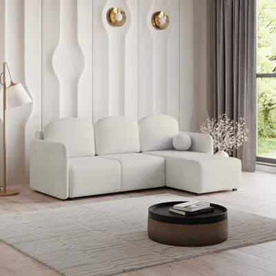 A modern living room with a cream sectional sofa, a round coffee table, and decorative wall panels.