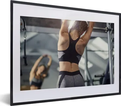 Produktbild von MuchoWow® MuchoWow® Gerahmtes Poster Eine junge Frau dehnt sich bei einem Fitnesstraining 40x30 cm - Poster mit zchwarzem Bilderrahmen - Bilderrahmen - Poster im Rahmen