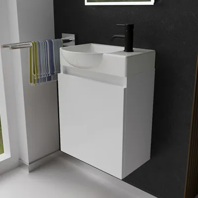 A modern white vanity unit with a sink and black faucet in a bathroom setting.