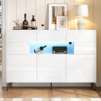 A white high-gloss sideboard with LED lighting, displaying bottles of wine and a vintage radio.
