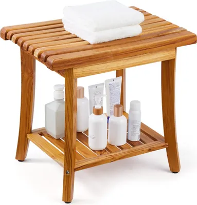 A wooden shower stool with towels on top and various bottles on the shelf below, set against a white background.