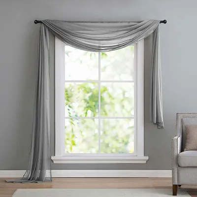 A sheer gray scarf-like curtain draped over a window.