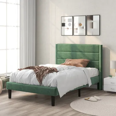 A bedroom scene with a green bed, white bedding, and decorative artwork on the wall.