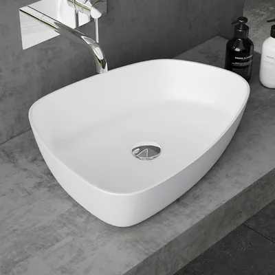 A white basin sink on a gray countertop with a chrome faucet.
