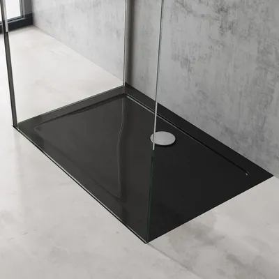 A modern shower tray with glass enclosure in a bathroom setting.