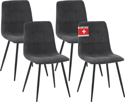 Four dark gray upholstered dining chairs with black metal legs are arranged in a row against a white background. One chair has a red and white tag attached to its back.