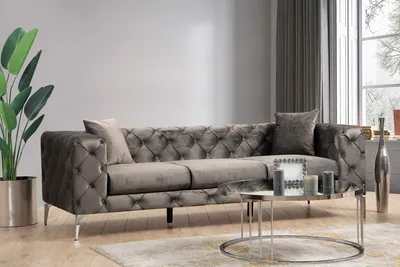 A modern living room scene featuring a tufted sofa, coffee table, and decorative items.