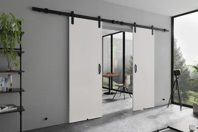 Modern interior with sliding doors, furniture, and a large window overlooking a landscape.
