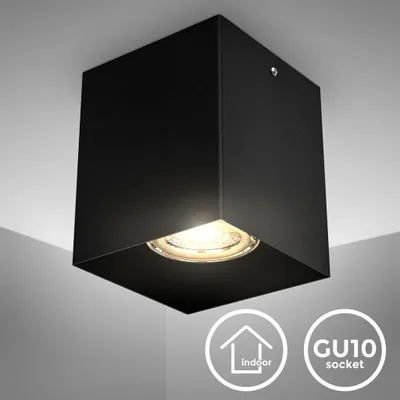 A black cube-shaped ceiling light with an exposed GU10 bulb.