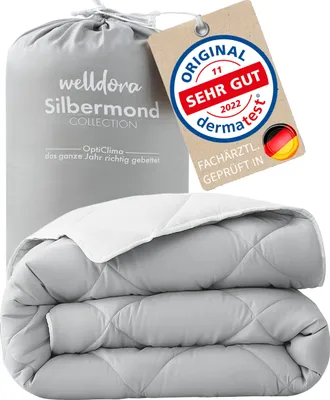 A folded duvet is presented in its packaging bag, with a product tag attached.