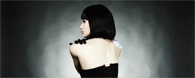 Produktbild von Wallario selbstklebendes Poster - Schöne Frau im schwarzen Kleid zeigt ihren Rücken, Größe: 50 x 125 cm