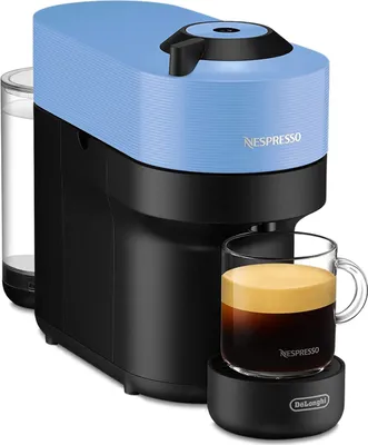 A Nespresso coffee machine is brewing coffee into a glass mug.