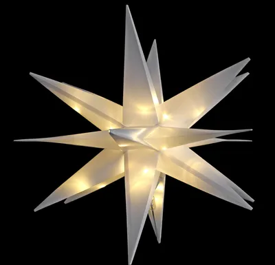 A white, star-shaped, illuminated decoration against a black background.