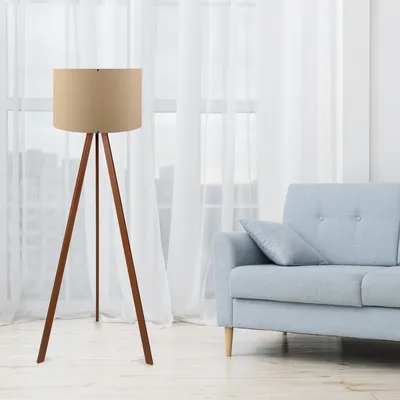 A floor lamp and a sofa are shown in a room with sheer curtains.