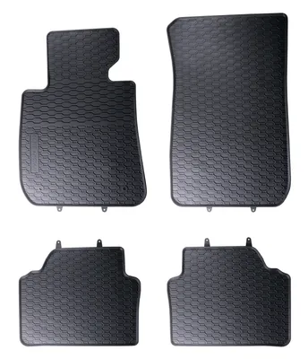 A set of four black rubber car floor mats with a textured pattern, arranged on a white background.