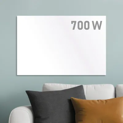 A white infrared heater with "700 W" text is mounted on a light blue wall above a white sofa with gray and brown pillows.