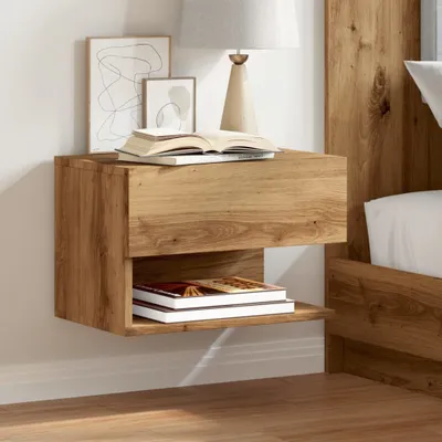 A wooden nightstand is mounted on a white wall next to a bed. The nightstand has a drawer on top and an open shelf below, with books and artwork on display.