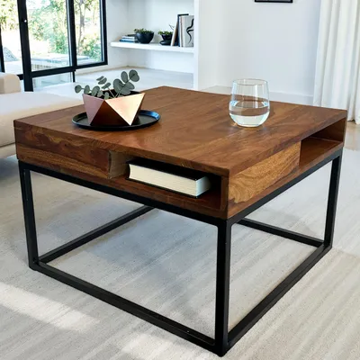 A square wooden coffee table with a black metal frame, placed in a living room setting.