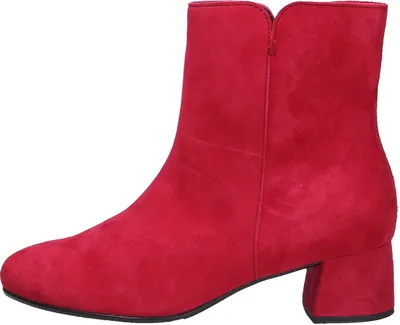 A red suede ankle boot with a block heel is shown against a white background.