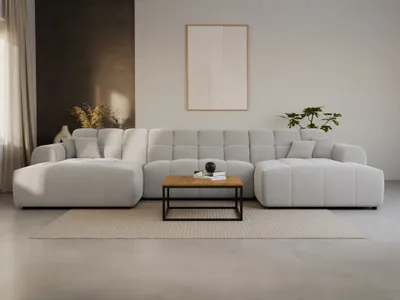A modern living room scene with a large, light gray sectional sofa on a beige rug.
