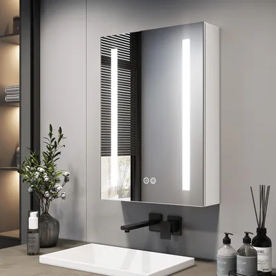 A modern bathroom with a sink, faucet, and illuminated medicine cabinet.