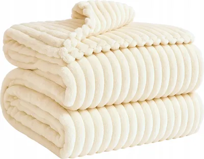 A stack of folded cream-colored blankets with a ribbed texture.