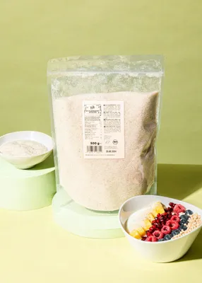 A bag of psyllium husks is shown next to a bowl of fruit and cereal, with a smaller bowl of psyllium husks in the background.