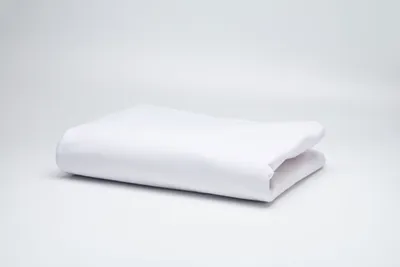 A white folded duvet cover is placed on a white surface with a light gray background.