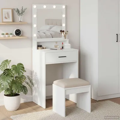A white vanity table with a lighted mirror and a stool in a room.