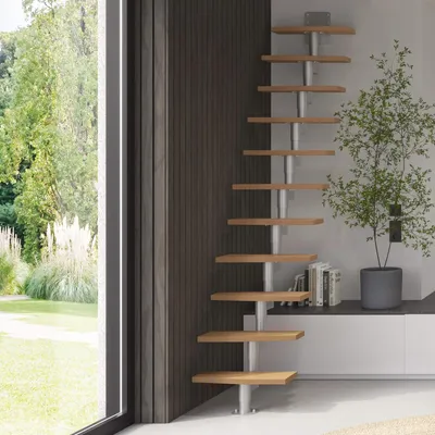 A modern interior with a space-saving staircase and a large window overlooking a garden.