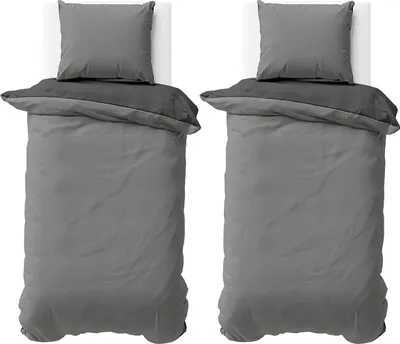 Two sets of bedding laid out on white surfaces.