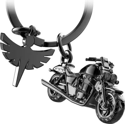 A close-up shot of a black metal motorcycle keychain with a charm of a winged figure.