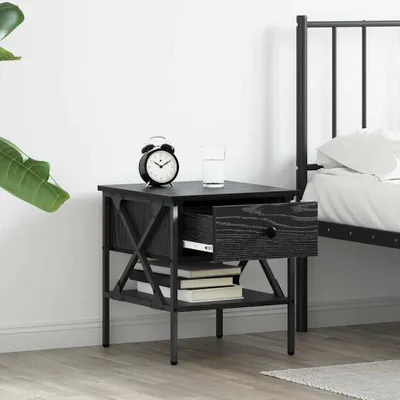 A black nightstand with an open drawer next to a bed.