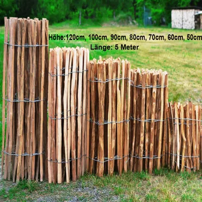 A collection of wooden fences of varying heights and lengths, displayed outdoors on a grassy area with a blurred green background.