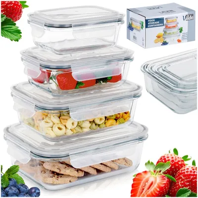 A stack of glass food storage containers filled with various food items, along with some fresh fruit and a product box.
