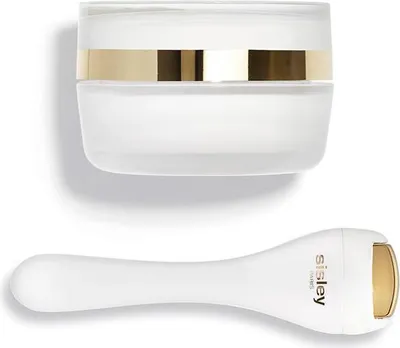 A white jar of cream and a white facial roller with gold accents are displayed on a white background.