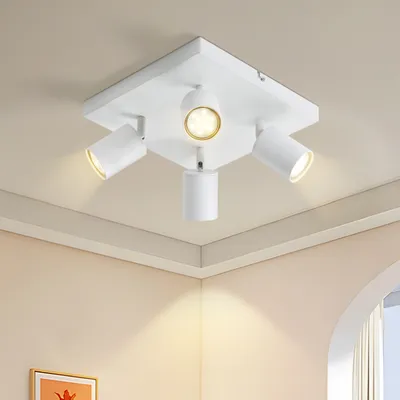 A white ceiling light fixture with four adjustable spotlights is mounted on a white ceiling.