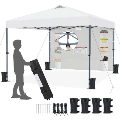 A person is shown setting up a white pop-up canopy tent. The tent is shown from the front, with accessories like stakes, ropes, and weights laid out in the foreground.