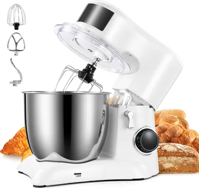 A white stand mixer with a stainless steel bowl and attachments, placed in front of baked goods.