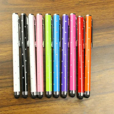 A collection of ten colorful stylus pens with rhinestones arranged in a row on a wooden surface.