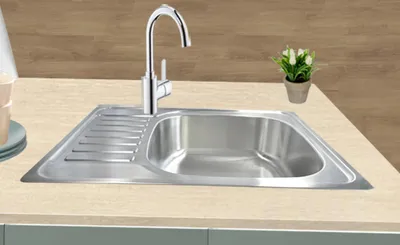 A stainless steel kitchen sink with a faucet and a small potted plant on a countertop.
