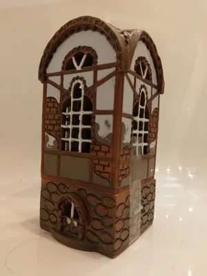 Das Keramikhaus ist in braunen, weißen und blassbraunen Tönen gehalten, mit einem Fachwerk-Design.