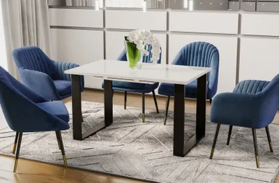 A dining room scene with a white high-gloss extendable dining table and four blue velvet chairs.